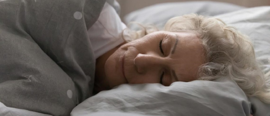 Older woman asleep on side in bed