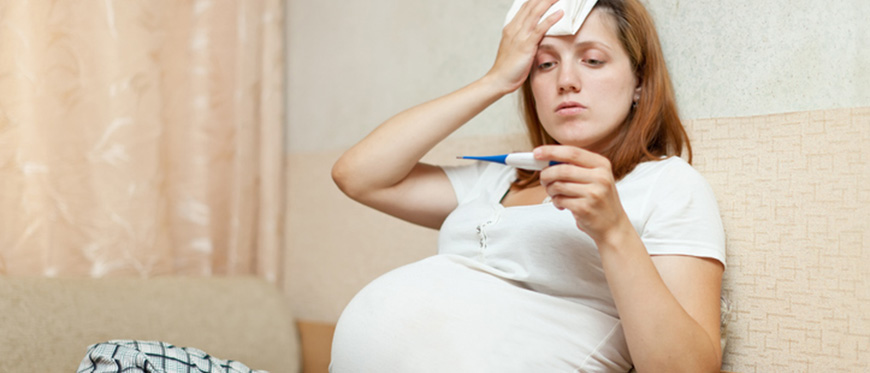 Pregnant woman taking her temperature