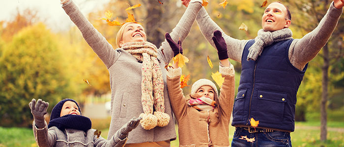 Family outdoors with upstretched arms 