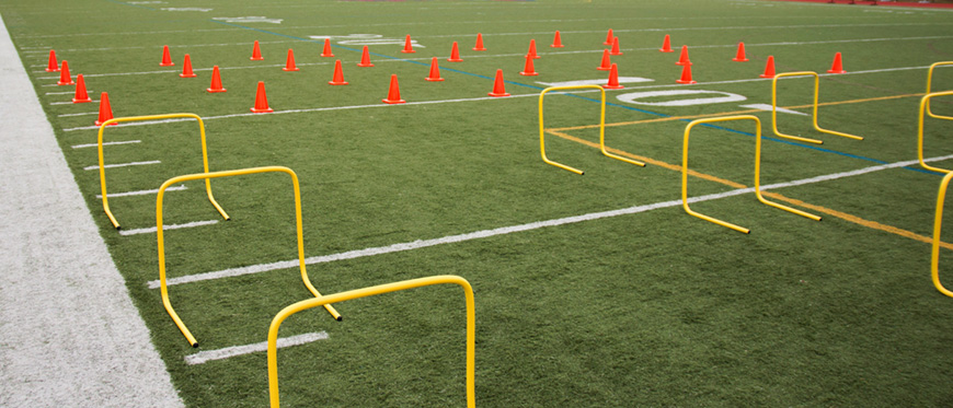 Football field set up with agility course for training.