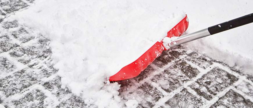 Red snow shovel pushing snow