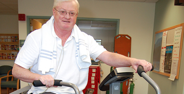 Older man riding a stationary bike