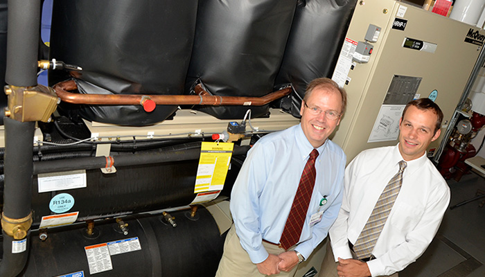 Richard Morley, CVMC Vice President of Support Services (left) and Tim Perrin, Senior Account Manager at Efficiency Vermont (right), in front of CVMC’s Templifier.
