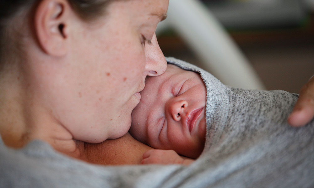 Mom with newborn snuggled under her shirt