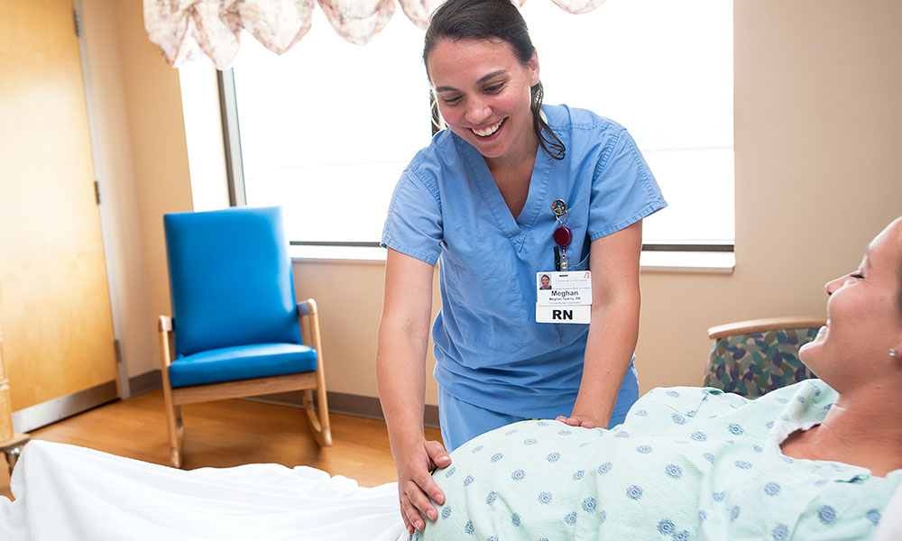 Nurse checking on mom-to-be in birthing center.