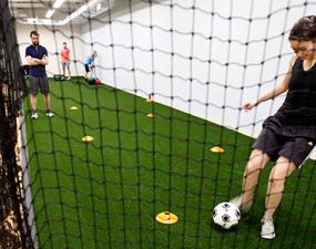 Patient kicking soccer ball into net during rehab