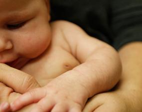 Baby held in mother's arms